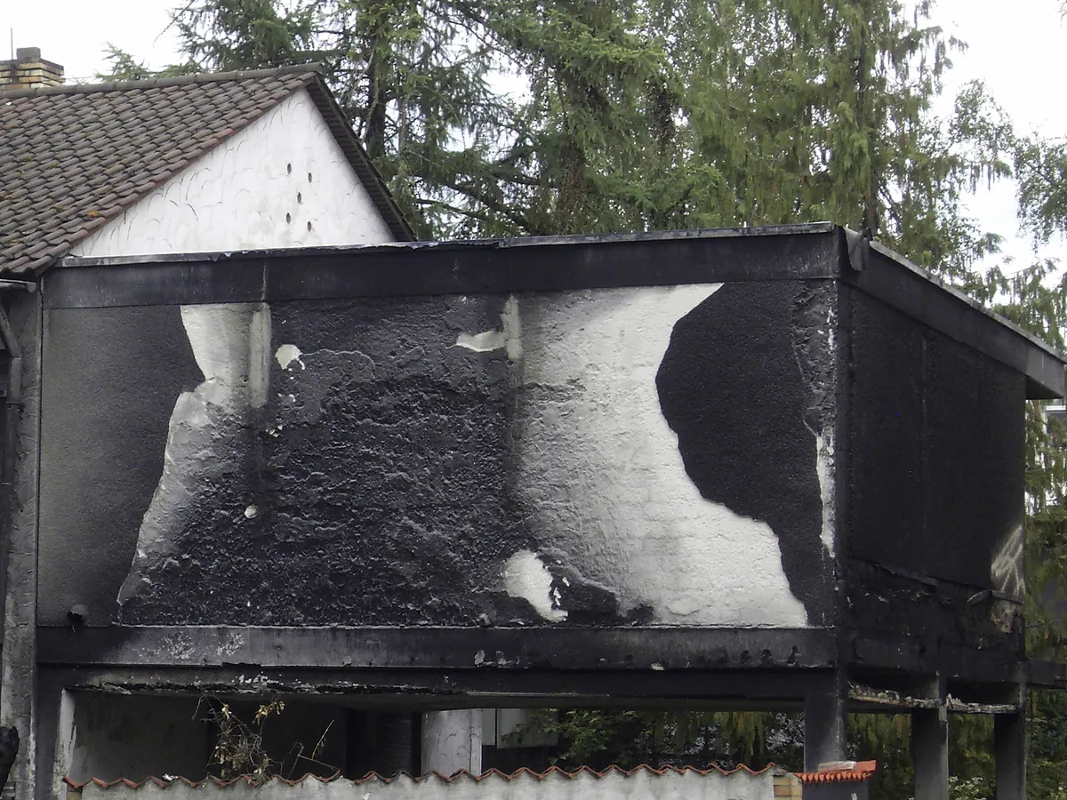 Rußgeschwärzte Fassade eines Wohnhauses nach einem Brand